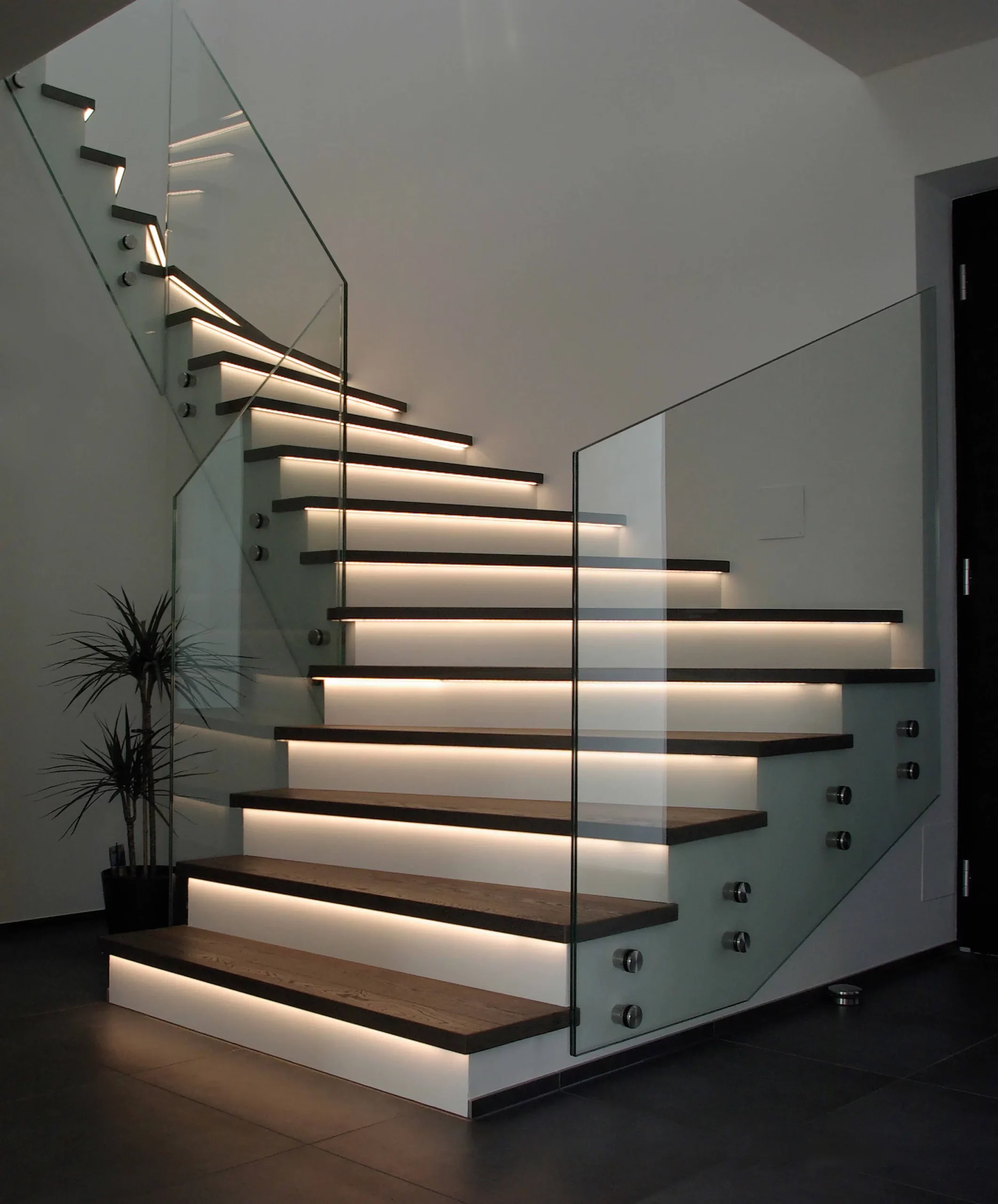 Eine moderne Treppe mit Glasgeländer und LED Beleuchtung an den Treppen - Stufen. T&K WOHNSTDIO - Raumausstattung, Bodenbeläge, Vinylboden, Parkett, Gardinen - Saarburger Straße 25, 67071 Ludwigshafen